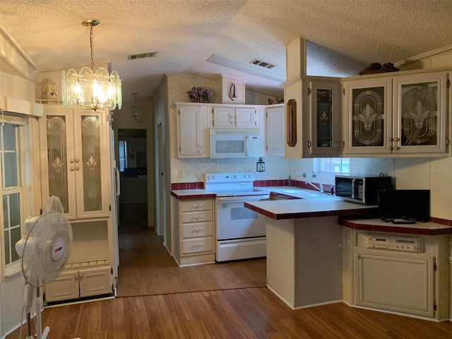 kitchen with light hardwood / wood-style flooring, lofted ceiling, white cabinets, and white appliances