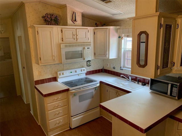 kitchen with white appliances, sink, vaulted ceiling, dark hardwood / wood-style floors, and a textured ceiling