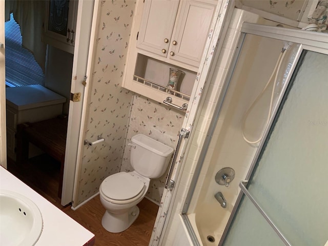 bathroom with a shower with shower door, sink, toilet, and hardwood / wood-style floors