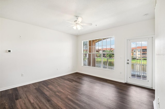 empty room featuring dark wood-type flooring and ceiling fan