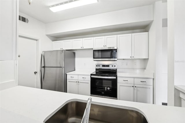 kitchen featuring white cabinetry, stainless steel appliances, and sink