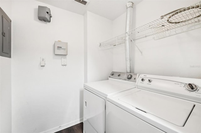 laundry room with dark hardwood / wood-style floors, washing machine and clothes dryer, and electric panel