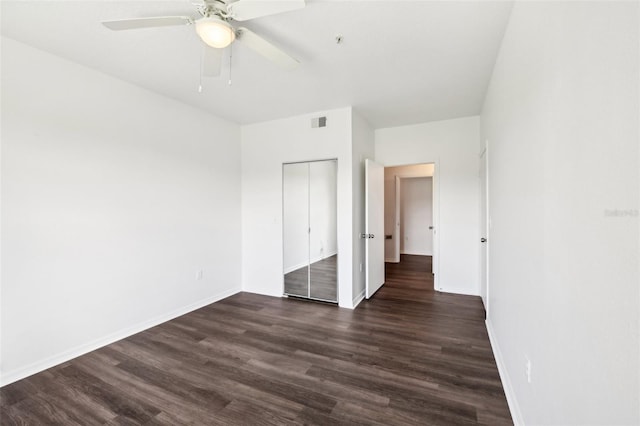 unfurnished bedroom featuring ceiling fan, dark wood-type flooring, and a closet