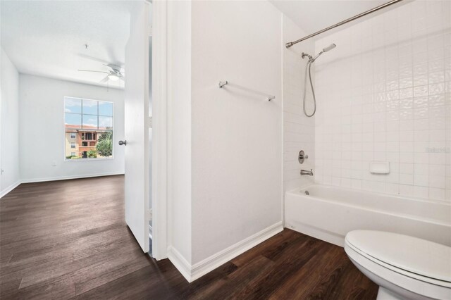 bathroom with tiled shower / bath, ceiling fan, hardwood / wood-style flooring, and toilet