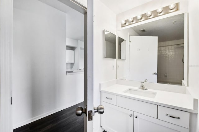 bathroom featuring vanity, tiled shower / bath, and hardwood / wood-style flooring