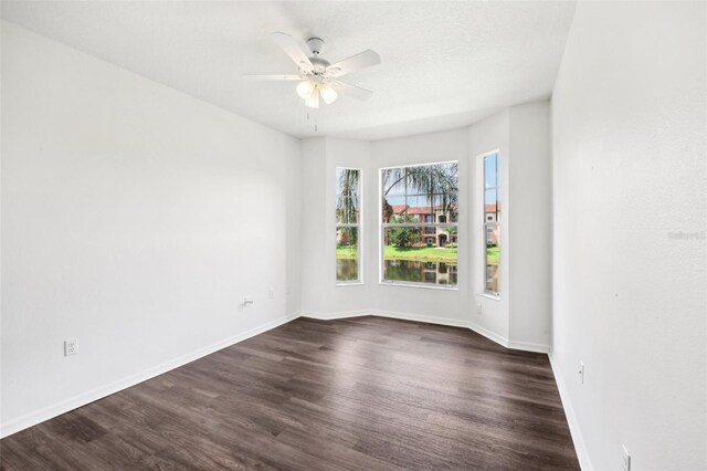 unfurnished room featuring ceiling fan and dark hardwood / wood-style flooring