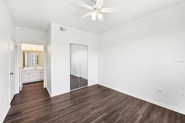 unfurnished bedroom featuring dark wood-type flooring, a closet, and ceiling fan