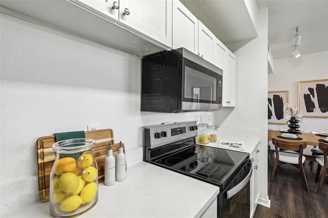 5530 Metrowest Blvd Unit 9-211, Orlando, FL 32811 - kitchen with appliances with stainless steel finishes, white cabinets, light countertops, and dark wood finished floors