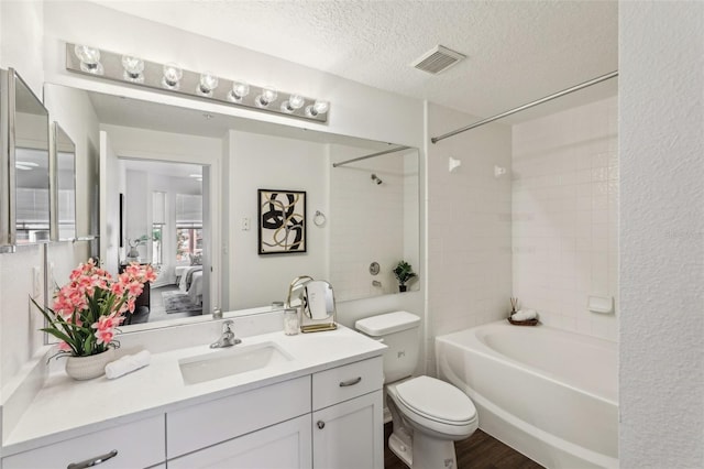 5530 Metrowest Blvd Unit 9-211, Orlando, FL 32811 - bathroom with vanity, bathing tub / shower combination, a textured ceiling, toilet, and wood finished floors