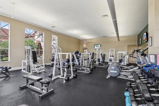 5530 Metrowest Blvd Unit 9-211, Orlando, FL 32811 - workout area featuring a textured ceiling and baseboards