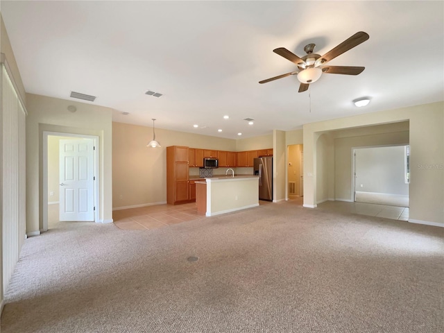 unfurnished living room featuring light carpet, sink, and ceiling fan