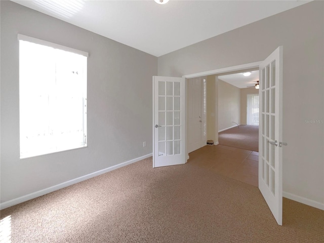 interior space with ceiling fan, light colored carpet, and french doors