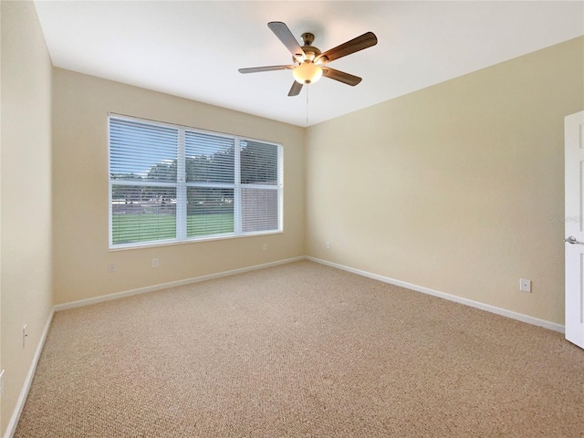 carpeted spare room with ceiling fan