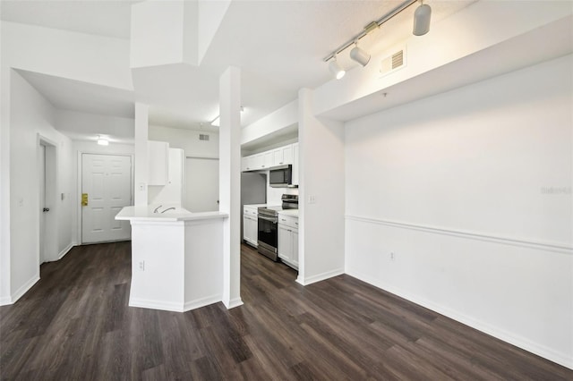 kitchen with white cabinets, dark wood-type flooring, appliances with stainless steel finishes, and rail lighting