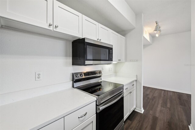 kitchen featuring appliances with stainless steel finishes, dark hardwood / wood-style flooring, rail lighting, and white cabinetry