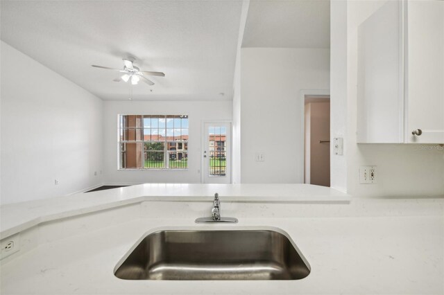 kitchen with white cabinets, sink, and ceiling fan