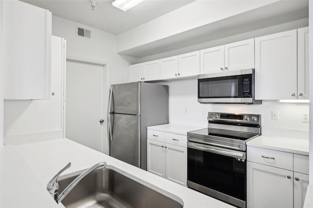 kitchen with sink, white cabinetry, and stainless steel appliances