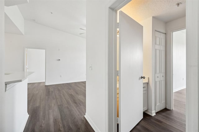 hallway with dark hardwood / wood-style flooring and a textured ceiling