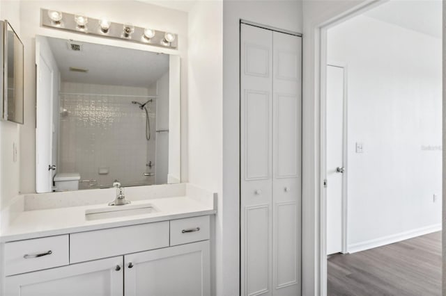 bathroom with vanity, wood-type flooring, and toilet