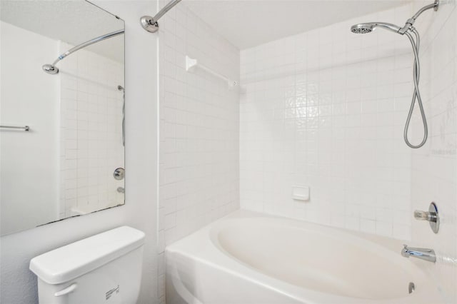 bathroom with tiled shower / bath combo and toilet