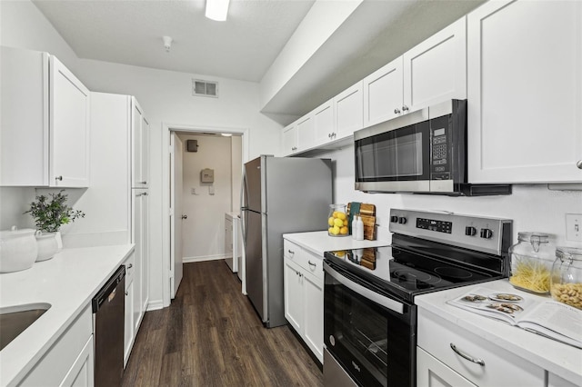 5530 Metrowest Blvd Unit 9-311, Orlando, FL 32811 - kitchen with appliances with stainless steel finishes, light countertops, white cabinets, and dark wood-type flooring