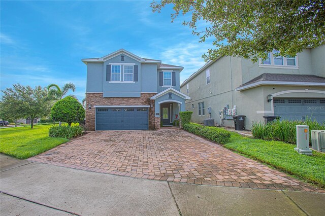 view of front property featuring a garage, central AC, and a front yard