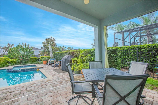 view of swimming pool featuring a patio, an in ground hot tub, and glass enclosure