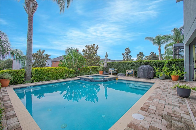 view of pool featuring an in ground hot tub, a patio, and a grill