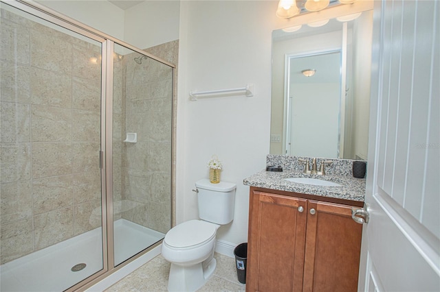 bathroom featuring vanity, walk in shower, tile patterned flooring, and toilet