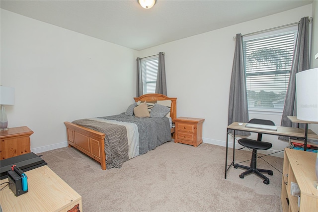 bedroom with multiple windows and light carpet