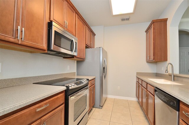 kitchen featuring light tile patterned flooring, sink, and appliances with stainless steel finishes