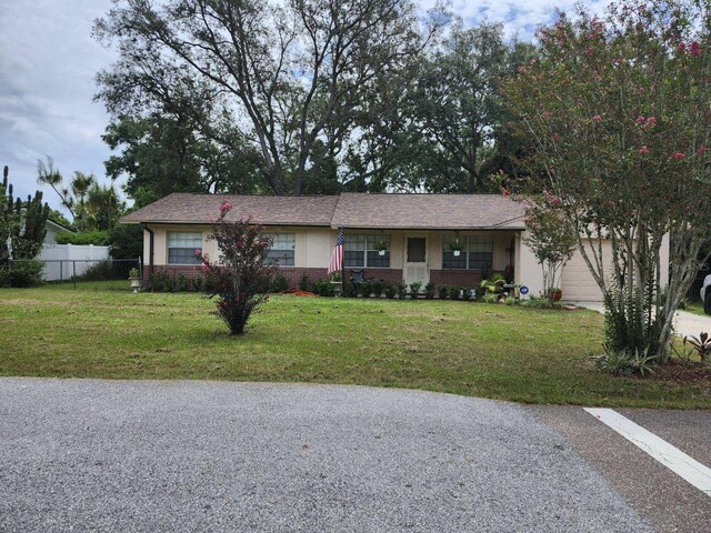 ranch-style home with a garage and a front lawn