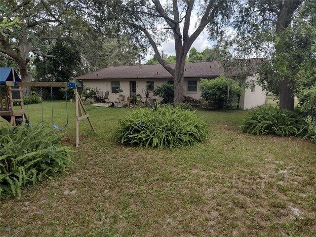 view of yard featuring a playground and a patio area