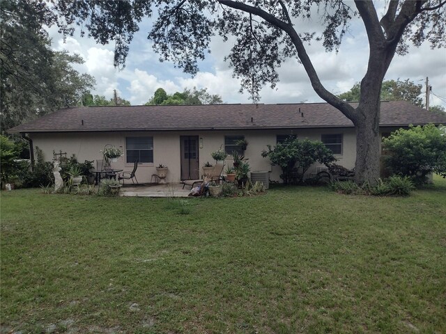 back of property featuring a yard, cooling unit, and a patio area