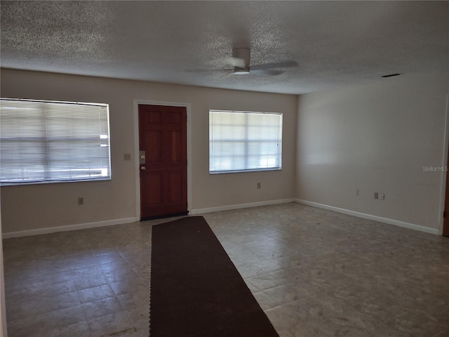 foyer featuring ceiling fan and a textured ceiling