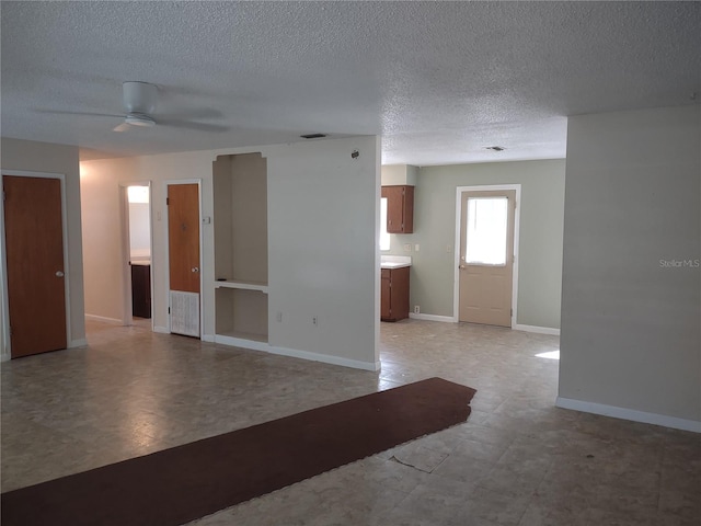 empty room with a textured ceiling and ceiling fan