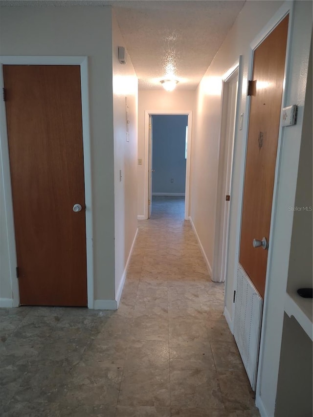 corridor featuring a textured ceiling