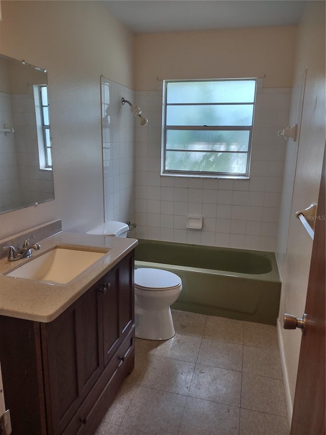 full bathroom featuring vanity, tile patterned flooring, toilet, and tiled shower / bath