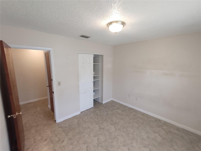 unfurnished bedroom with a closet and a textured ceiling