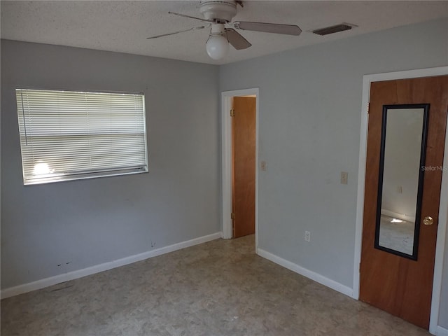 unfurnished room with a textured ceiling and ceiling fan