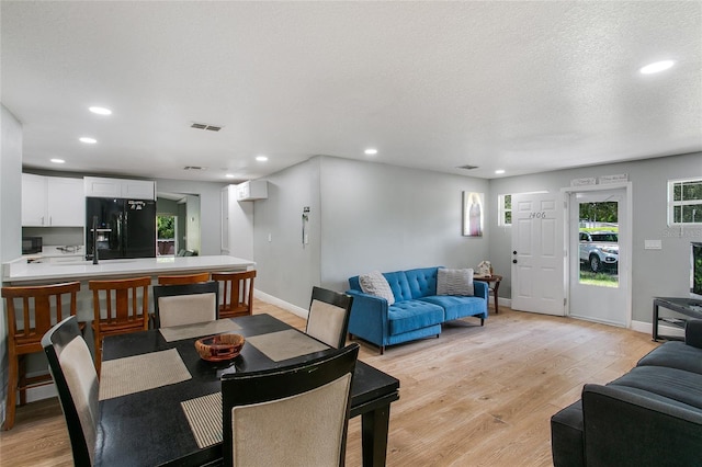 dining area featuring recessed lighting, visible vents, a textured ceiling, and light wood finished floors