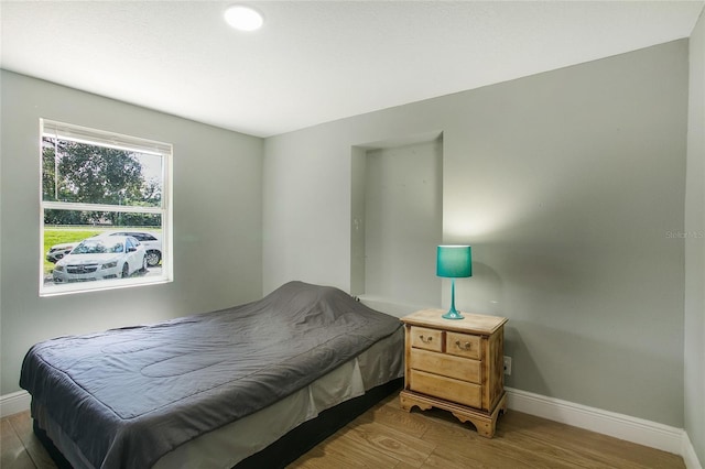 bedroom with baseboards and wood finished floors