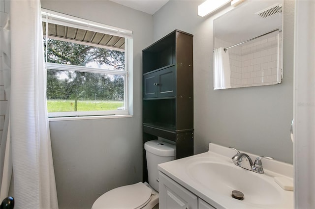 bathroom featuring a shower with curtain, visible vents, vanity, and toilet