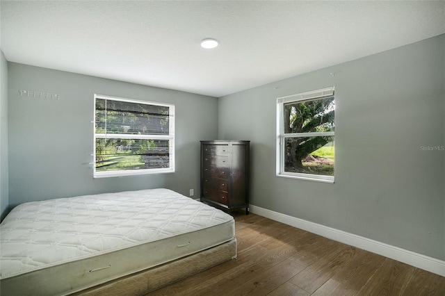 bedroom with baseboards and wood finished floors