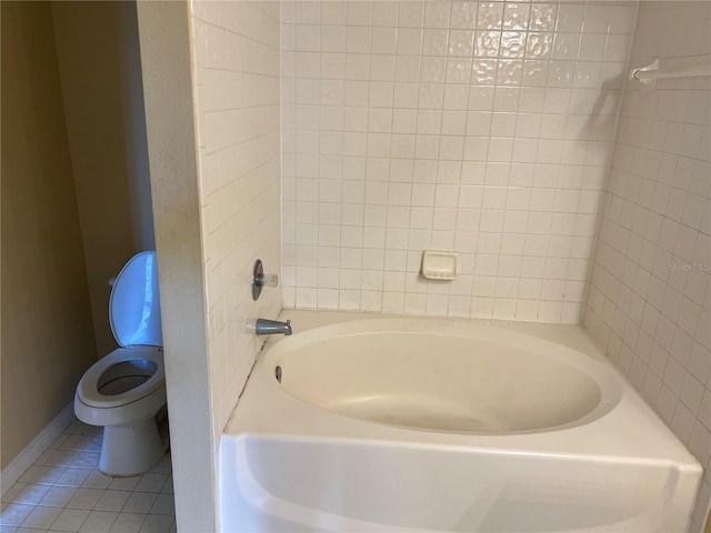 bathroom featuring toilet, a tub, and tile patterned floors