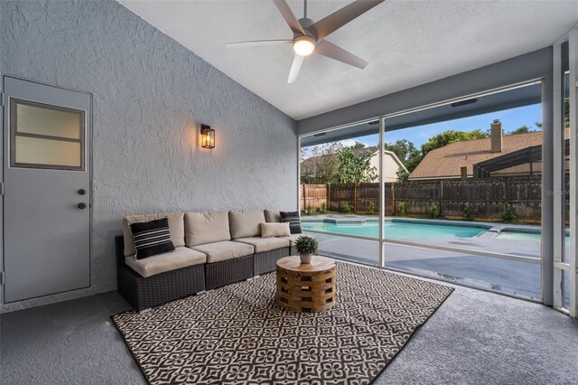 carpeted living room with a textured ceiling, vaulted ceiling, and ceiling fan