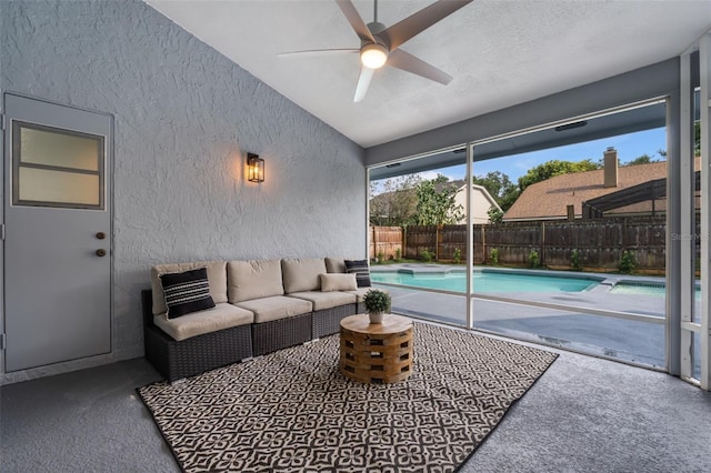 exterior space with ceiling fan, carpet flooring, vaulted ceiling, and a textured ceiling