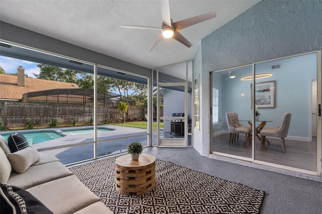 sunroom with ceiling fan and vaulted ceiling