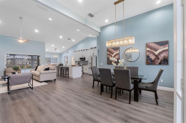 dining space featuring light wood-type flooring, high vaulted ceiling, and ceiling fan