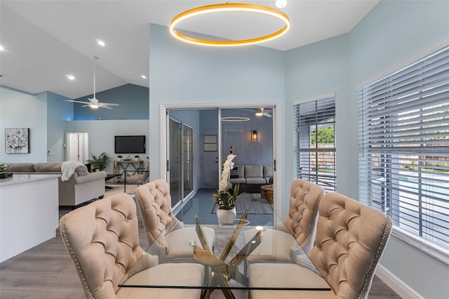 dining room with high vaulted ceiling, hardwood / wood-style flooring, and ceiling fan